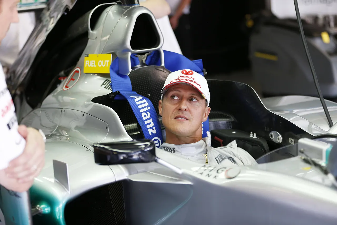 Michael Schumacher sitzt im Cockpit eines Rennautos.