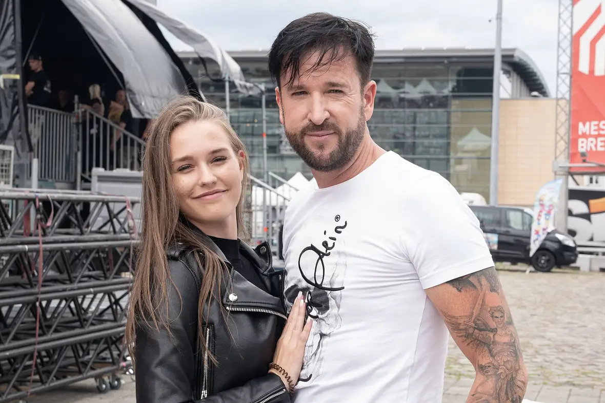 Michael Wendler mit seiner Frau Laura Müller. Sie schmiegt sich lächelnd an ihn. 