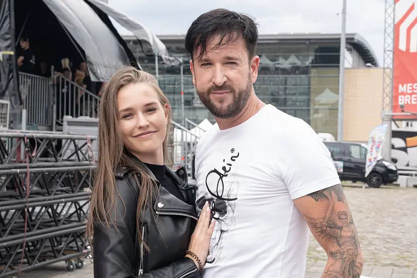 Michael Wendler mit seiner Frau Laura Müller. Sie schmiegt sich lächelnd an ihn. 