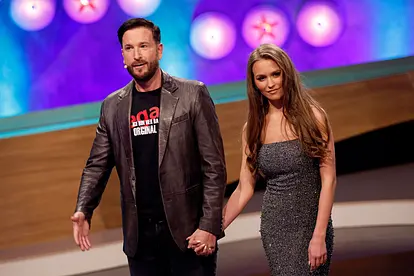 Michael Wendler und Laura Müller stehen Hand in Hand in einem TV-Studio.