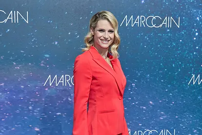 Michelle Hunziker trägt einen roten Blazer, offene Haare und strahlt in die Kamera. 