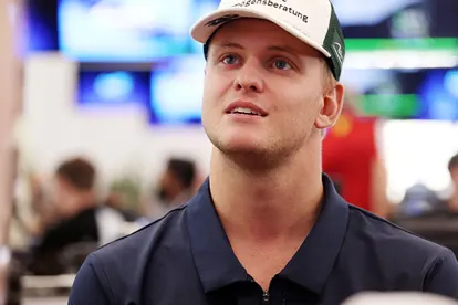 Mick Schumacher: Muss er nun operiert werden? Mick Schumacher trägt eine Kappe und ein dunkelblaues Hemd. Er blickt mit leicht geöffnetem Mund nach oben.