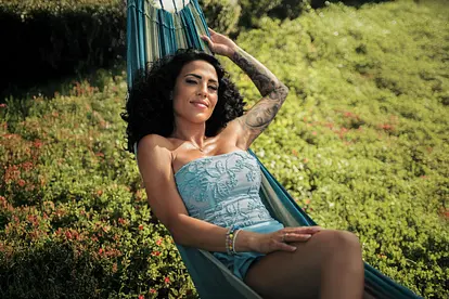 Elena Miras in einem blauen Kleid in einer Hängematte auf einem Promofoto zu "Make Love, Fake Love".