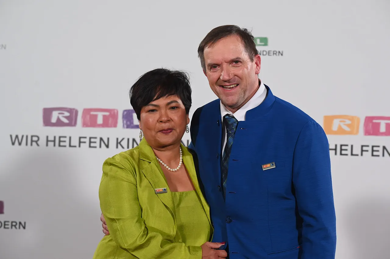 Narumol und Josef posieren nebeneinander und blicken in die Kamera.