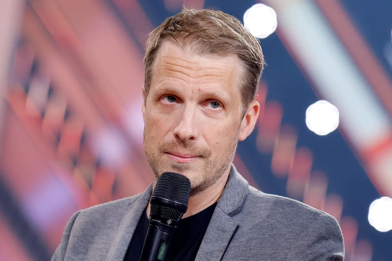 Oliver Pocher, hier ernst vor einem Mikrofon stehend, ist sauer auf seine TV-Kollegen Joko und Klaas.