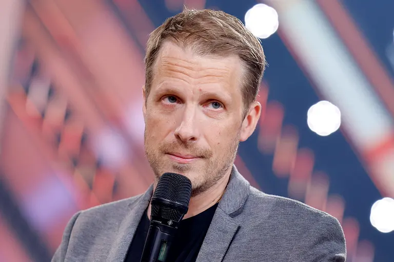 Oliver Pocher, hier ernst vor einem Mikrofon stehend, ist sauer auf seine TV-Kollegen Joko und Klaas.
