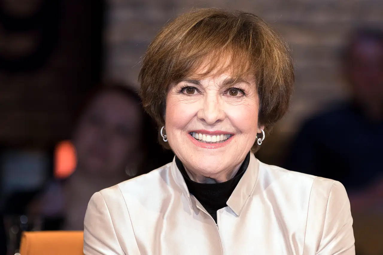 Paola Felix lächelt breit in die Kamera. Sie trägt eine Seidenbluse und Creolen.  - Foto: IMAGO / Stefan Schmidbauer