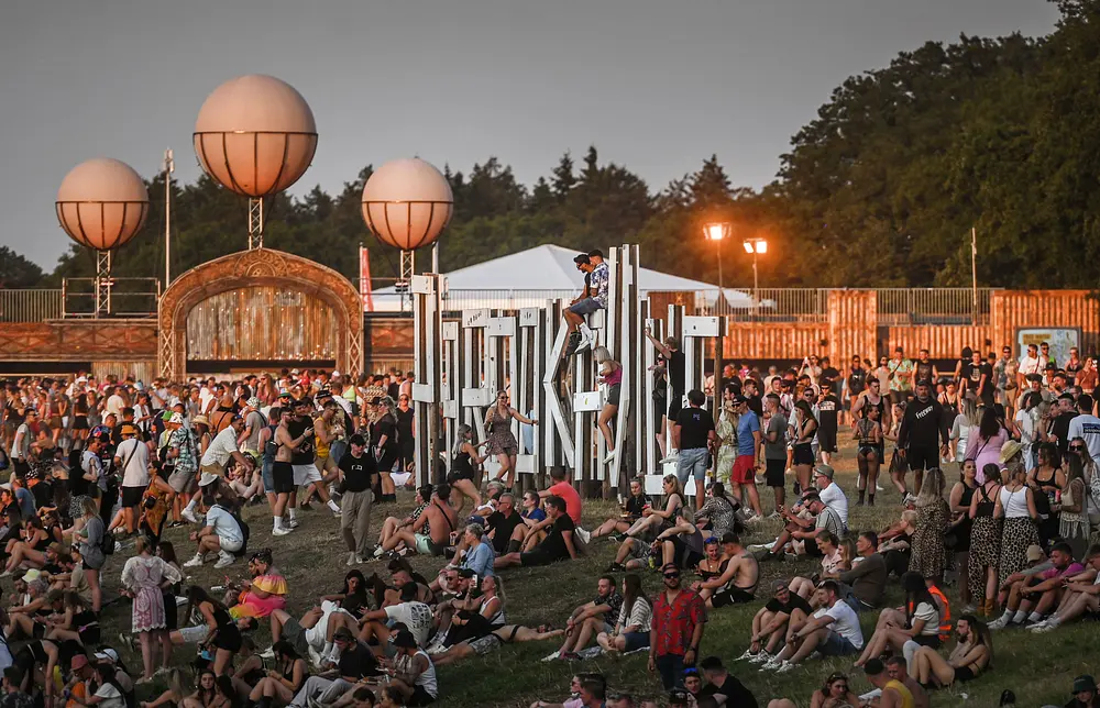 Parookaville Festival, Menschen sitzen auf dem Rasen Parookaville Festival, Menschen sitzen auf dem Rasen