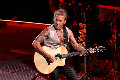 Peter Maffay steht auf der Bühne und spielt Gitarre.