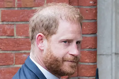 Prinz Harry trägt einen Anzug und wird in London mit ernster Miene von Fotografen abgelichtet.