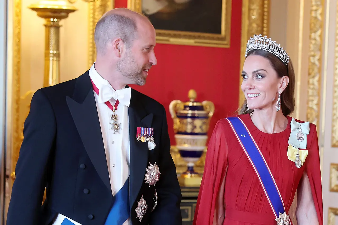 Prinz William und Prinzessin Kate, beide edel gekleidet, schauen sich verliebt an. Sie trägt eine Krone und Diamantohrringe.