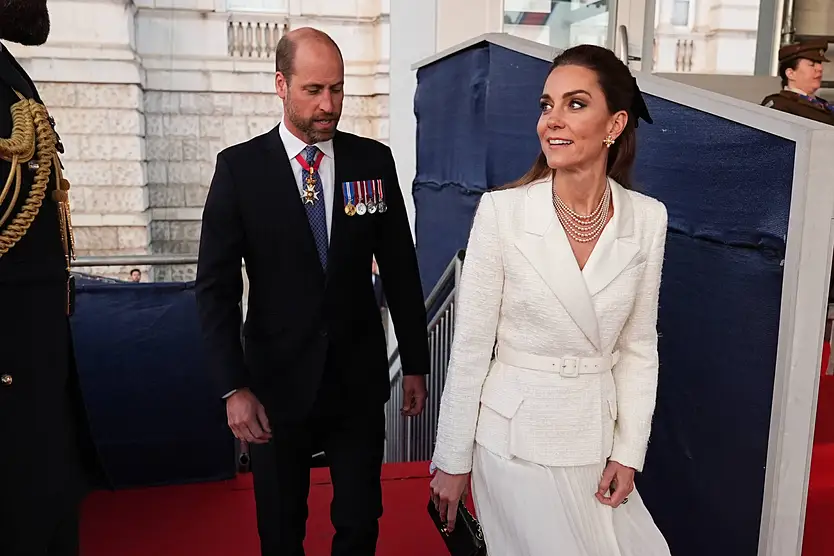 Prinz William und Prinzessin Kate in London. Sie trägt ein weißes Kostüm, er einen schwarzen Anzug.