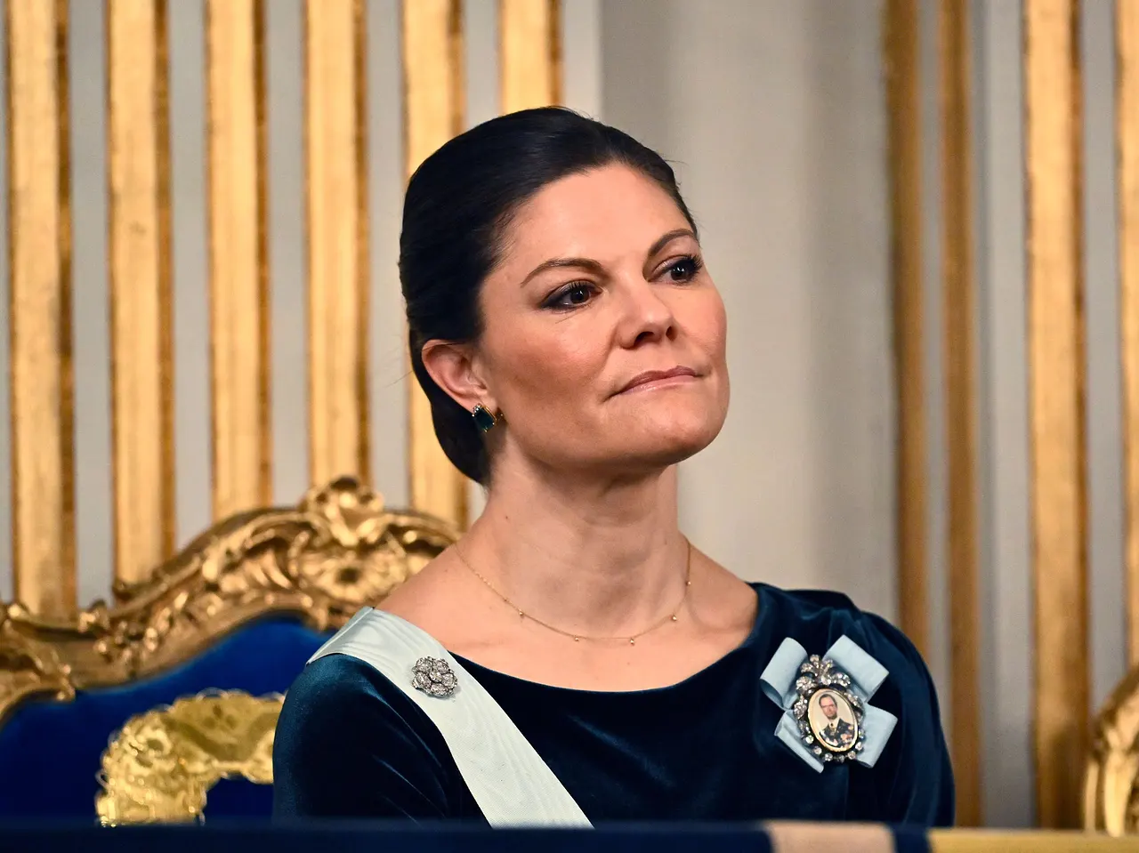 Prinzessin Victoria sitzt auf einem Stuhl und blickt mit ernster Miene in die Ferne.