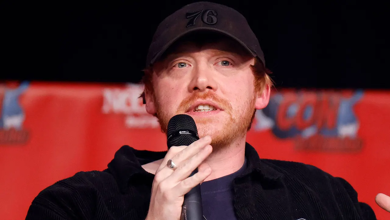 Schauspieler Rupert Grint mit schwarzer Kappe am Mikro
