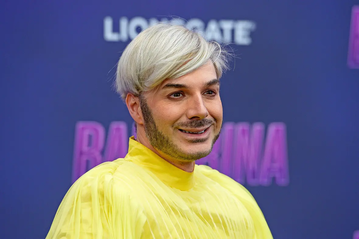 Sam Dylan in einem gelben Oberteil bei einer Premiere.