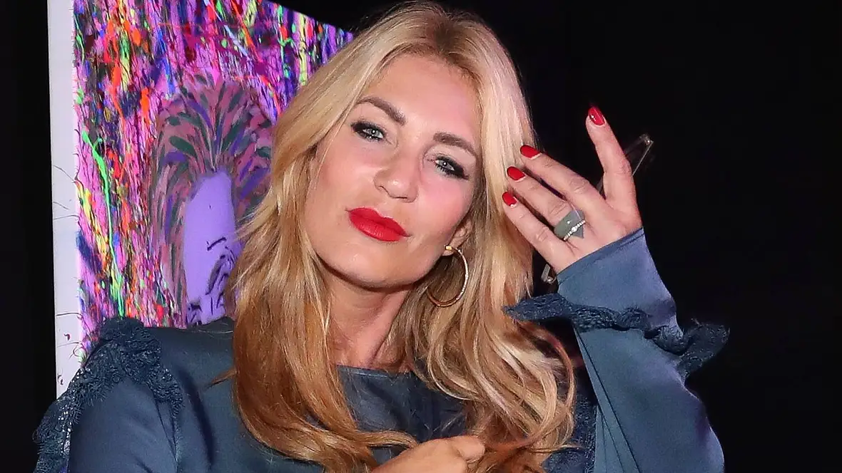 Promi Sarah Kern schaut verführerisch und geschminkt auf einer Show in die Kamera.