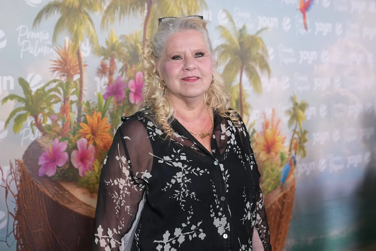 Silvia Wollny posiert auf dem roten Teppich. Sie hat die Haare halb hochgesteckt und eine Brille auf dem Kopf. 