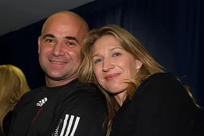 Steffi Graf kuschelt sich lächelnd an Andre Agassi.