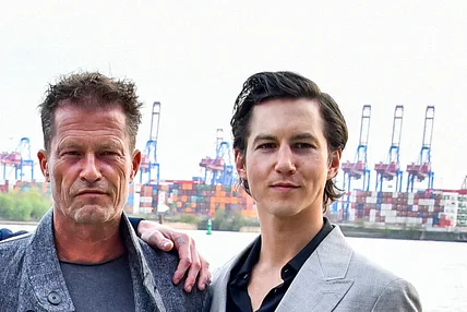 Til Schweiger und Tim Oliver Schulz stehen zusammen am Hafen in Hamburg