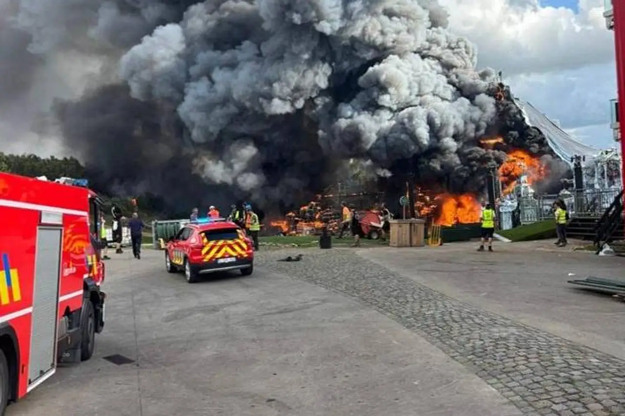 Die Bühne des "Tomorrowland"-Festivals steht am Mittwoch, 16. Juli, in Flammen. Dichter Rauch und Feuerwehrautos sind zu sehen.