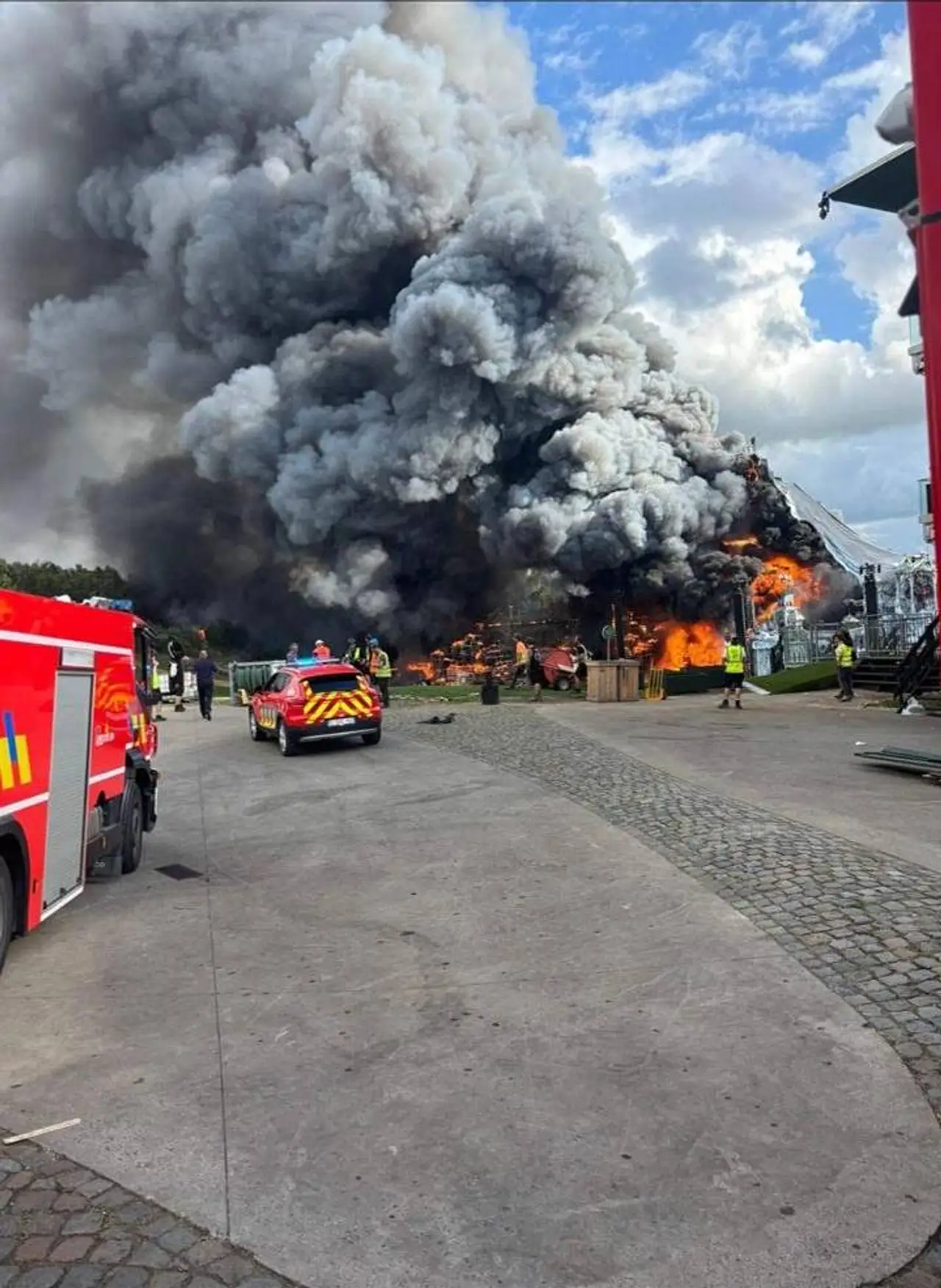 tomorrwland-2025-bühne-in-flammen Die Bühne des Tomorrowland-Festivals steht am Mittwoch, 16. Juli, in Flammen. Dichter Rauch und Feuerwehrautos sind zu sehen. - Foto: IMAGO / Belga
