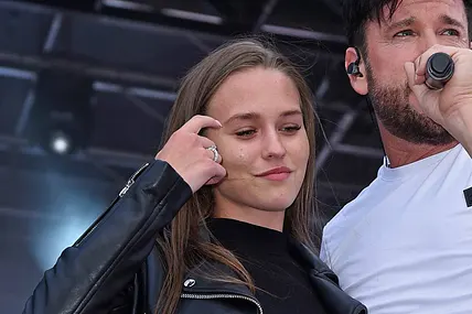 Laura Müller kratzt sich an der Stirn, während sie neben Michael Wendler auf der Bühne steht. 