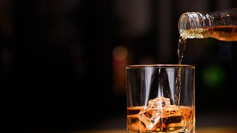 Whisky wird in ein Whisky Glas gegossen. - Foto: iStock/ OlegEvseev