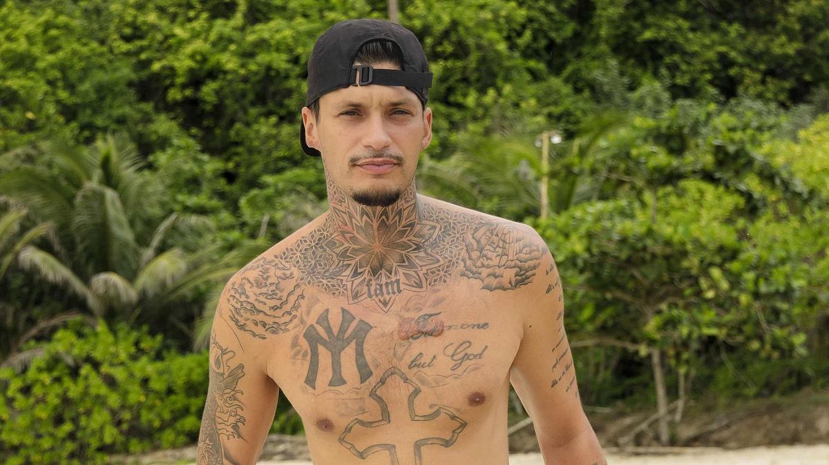 Yasin Mohamed präsentiert seine Tattoos am Strand