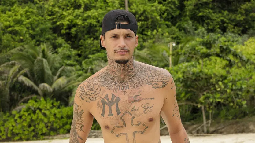 Yasin Mohamed präsentiert seine Tattoos am Strand